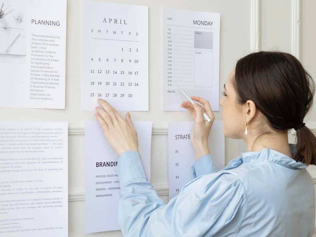 A woman making notes on a wall calender